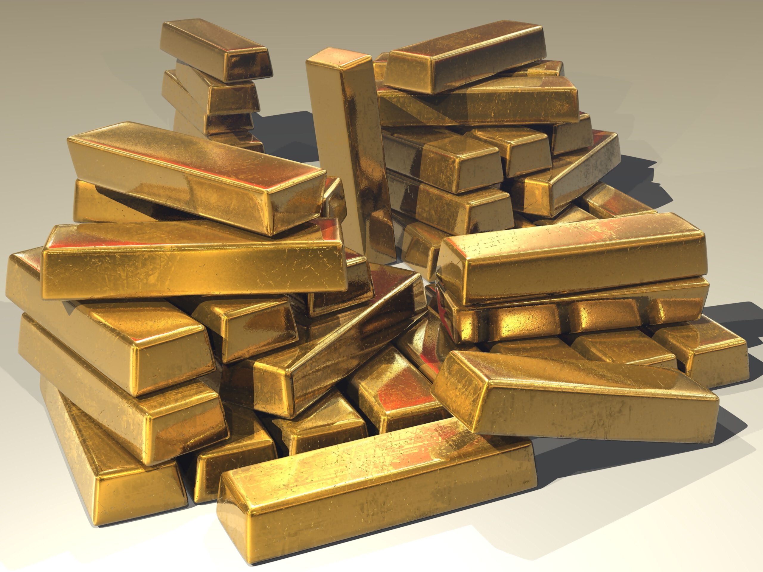 Sztabki złota na białym tle jako przykład surowca do inwestycji
